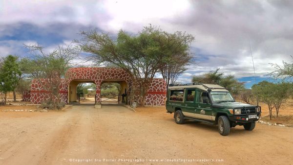 Samburu National Reserve entrance gate with safari vehicle in Kenya’s arid wilderness
